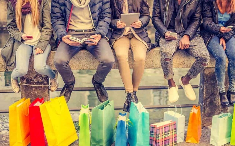 A group of young shoppers sitting with their bags