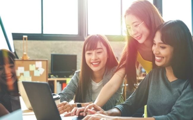 Three women looking at a laptop brainstorming ideas